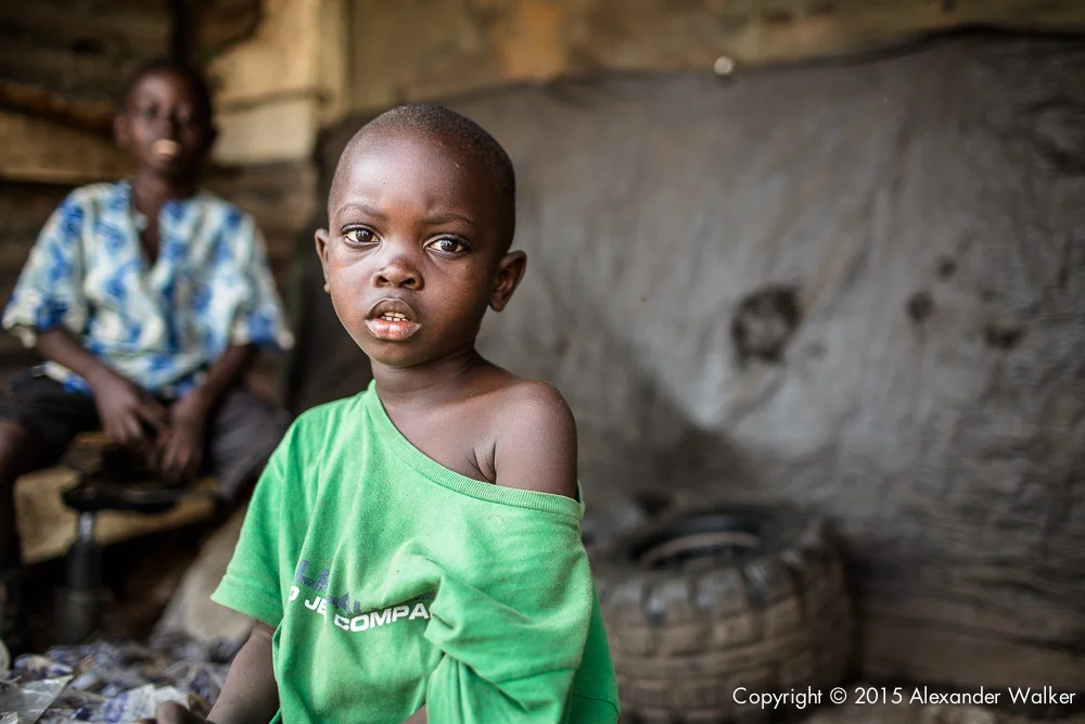 Osman 5 sits outside his family home on the rubbish dump in which they live. One of many in Freetown, Sierra Leone. He and his family sort through the rubbish on the dump continuously, looking for anything valuable which can either be recycled, or sold on. Comic Relief awarded Childhope UK funds to work with local charity Street Child Sierra Leone to help more than one thousand children escape hazardous work, reunite with their families and get into education. The project identifies the most vulnerable children on the streets and provide them with immediate practical support such as food, healthcare and clothing.