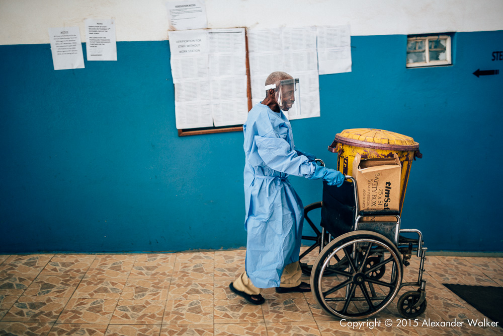  A man pushing a wheelchare with a bin of biologial wase at the OLA During Childrens Hospital, GAVI Alliance.  Comic Relief has funded GAVI since 2012 and awared funds in 2014 to purchace and deliver three lifesaving Vaccines to hundres of thousands 