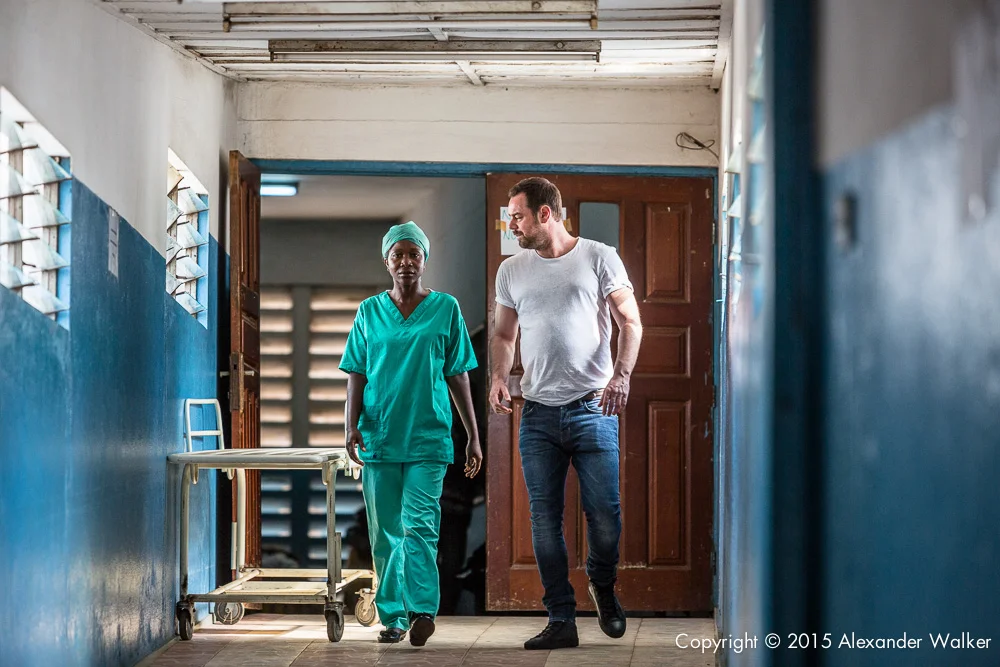 Danny Dyer with Nurse Lucia during a visit to the OLA During Childrens Hospital, GAVI Alliance. Comic Relief has funded GAVI since 2012 and awared funds in 2014 to purchace and deliver three lifesaving Vaccines to hundres of thousands of children in a selected number of African countries. Immunisation is one of the most effective ways of preventing children from dying from diseses. In africa alone, 600,000 children each year could be saved in vacccine programmes were fully implemened. Most countries have now introduced immunisation programmes in their national health plans, but almost a quater of african children are stil not being vaccinated adequately.