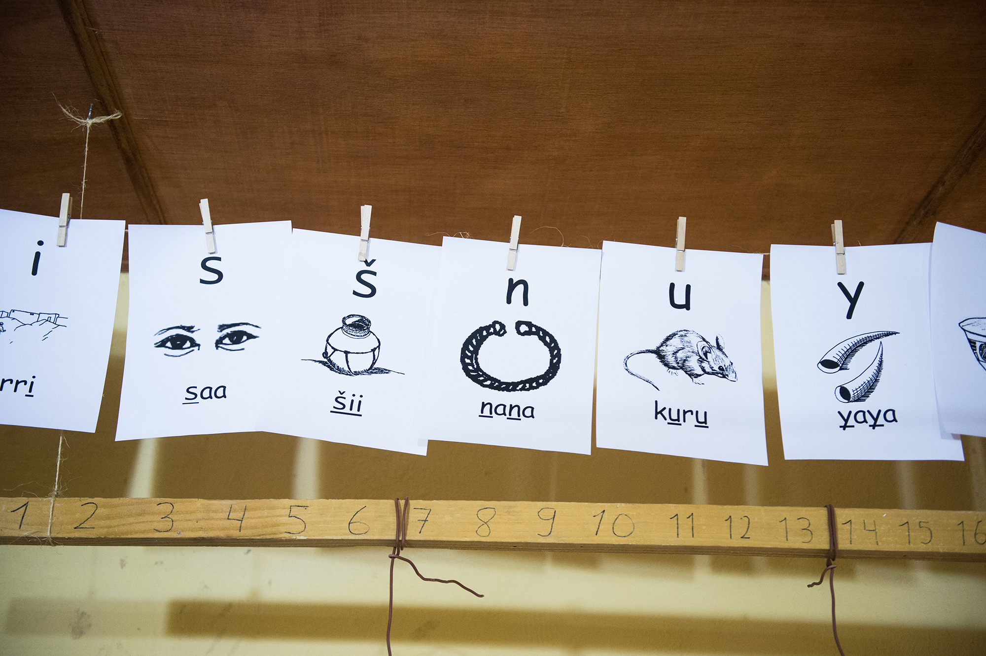 With the help of veteran linguists, and building on an alphabet that had already been created, Rivers uses pictures to help people learn the sounds of letters and the meaning of words. This banner hangs in a small room where he trains teachers and develops curriculum.