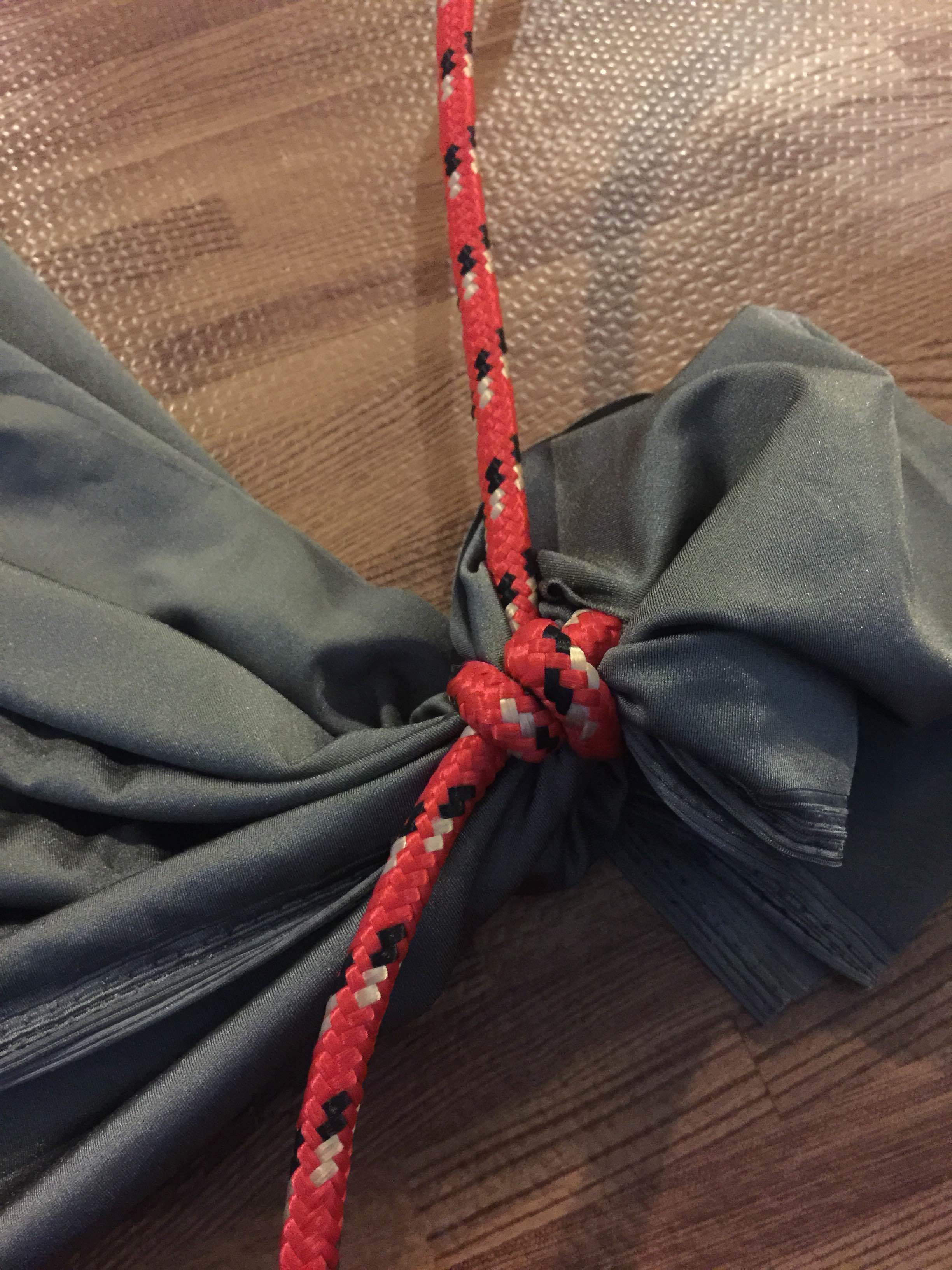 Step 3 : String tie a knot around the fabric, and then tie a second knot under the 1st knot (This makes it so that the rope is supported by the knot--not by the fabric). 