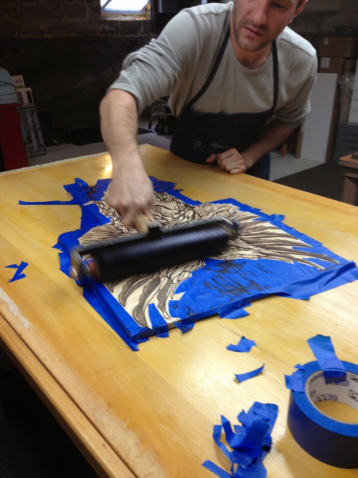 Inking right over the tape masking. The tape is pulled off just before the paper is placed on the block and burnished. 