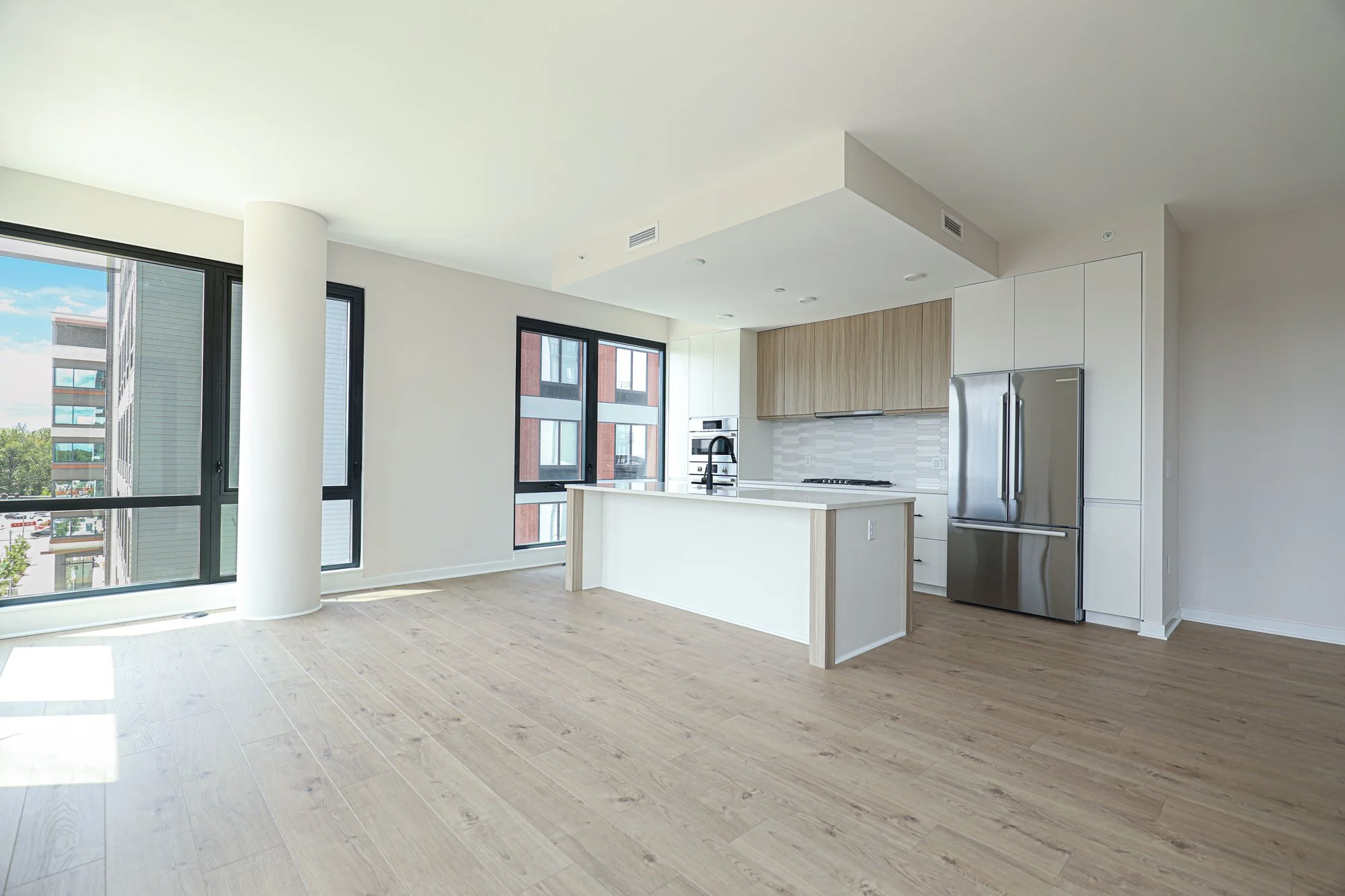 Commercial interior photography of an unfurnished condominium emphasizing architectural design and spacious layout.