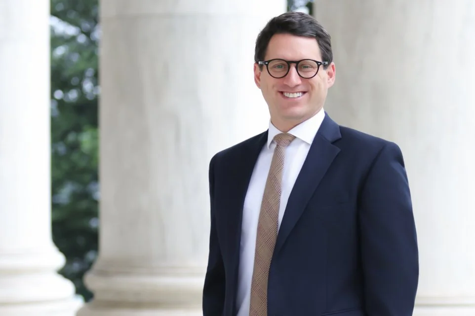 Professional executive portrait with natural light and architectural backdrop in Washington, DC.