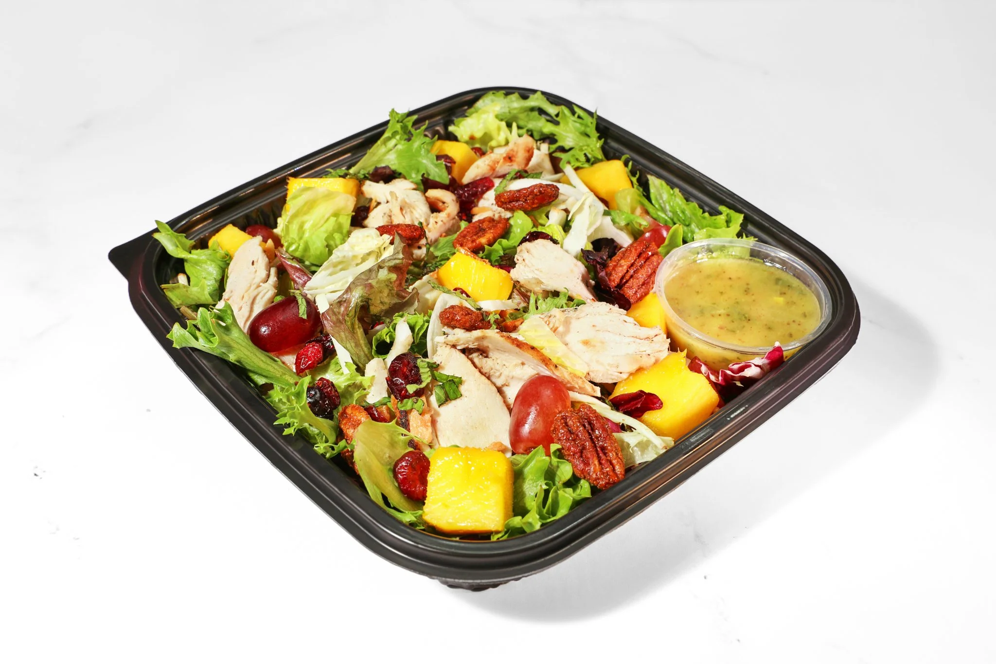 Restaurant food photography of a fresh entrée salad with seasonal vegetables and house-made ingredients.