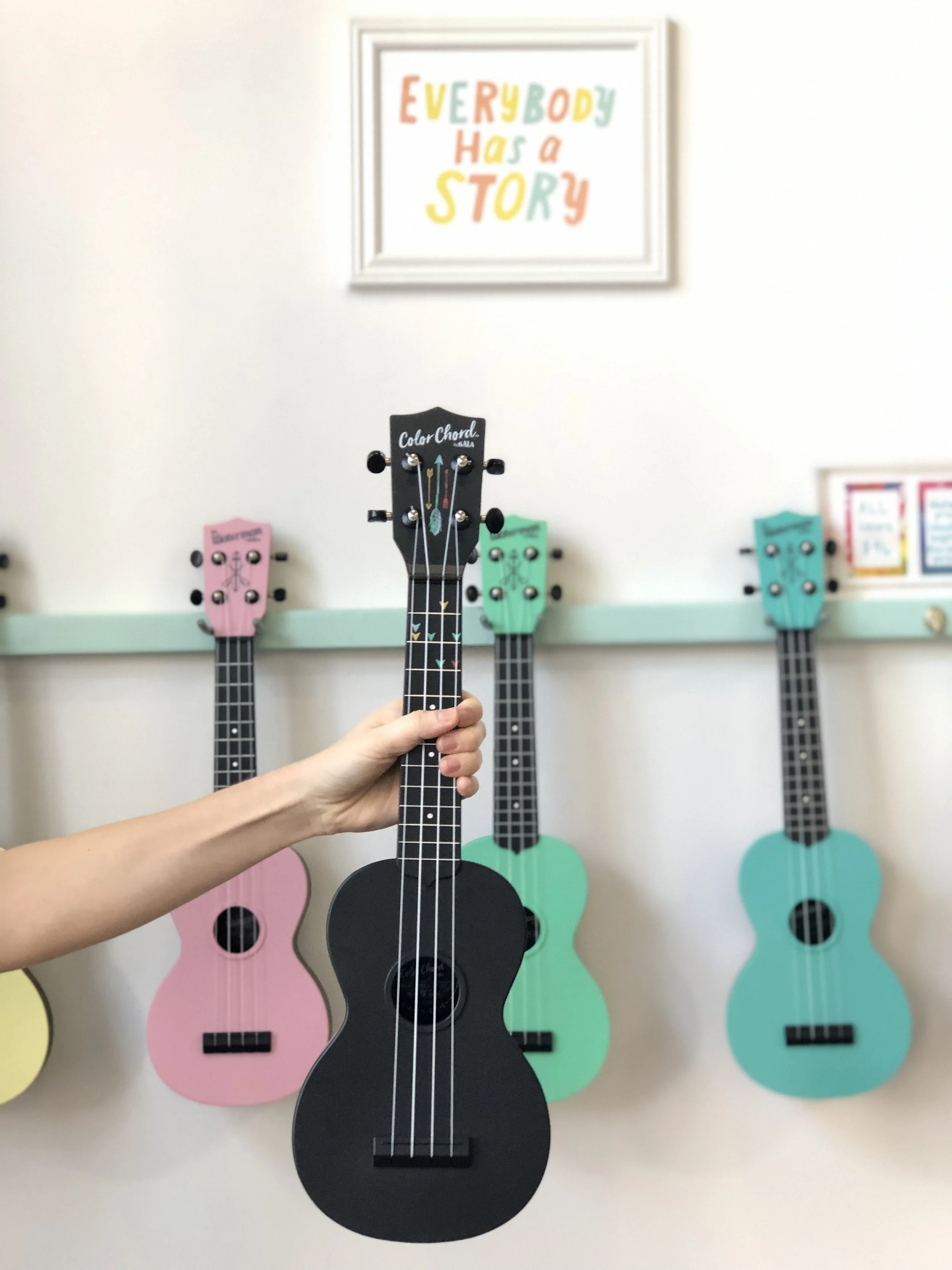 The colorful Waterman ukuleles behind the Color Chord are the same instrument but without the coding system. Life hack: you can use sticky dots from an office supply store to create the color system.