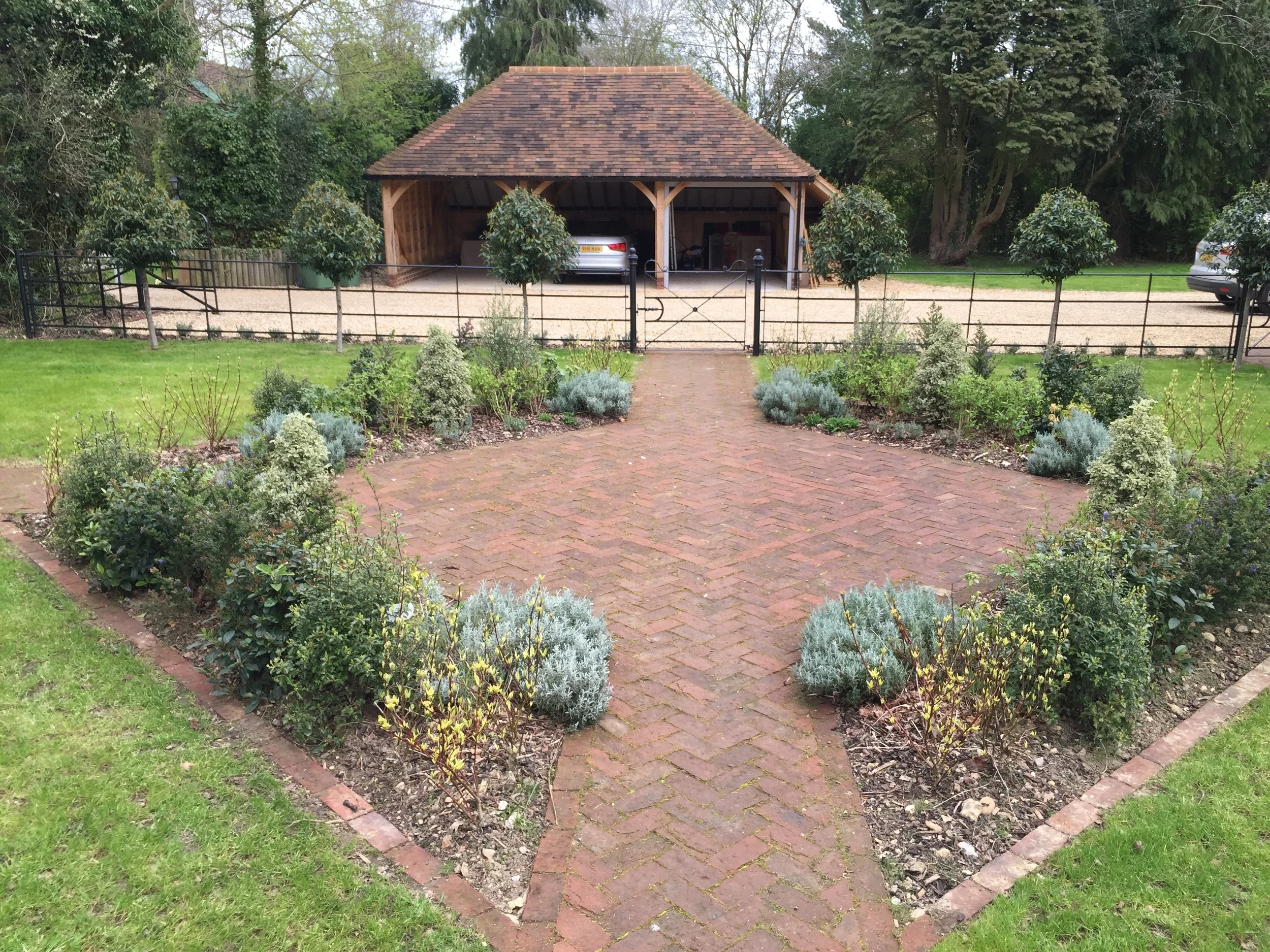 A new oak framed garage provides inspiration for the choice of materials - brick pavers and estate railings