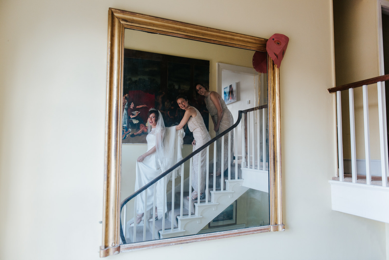 Bride and bridesmaids look into the mirror in awe as they see br