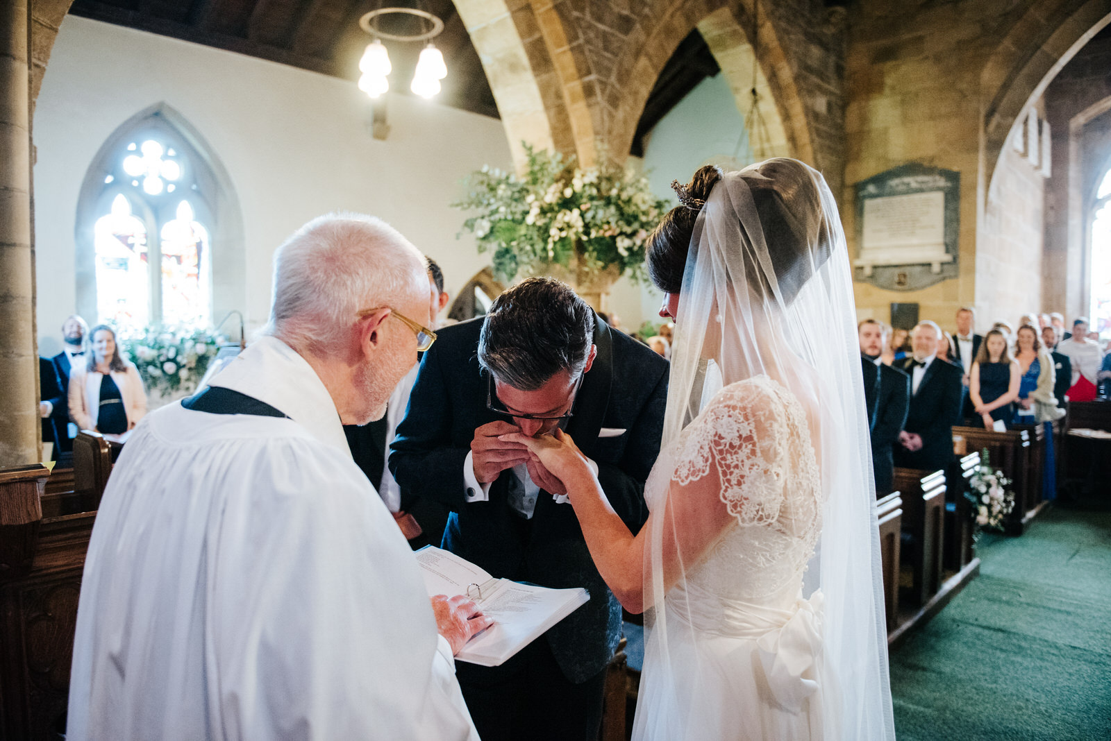 Groom kisses Bride on the finger after putting a ring on it