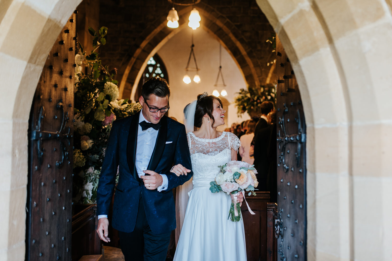 Bride and Groom exit Felixkirk Church while Bride smiles