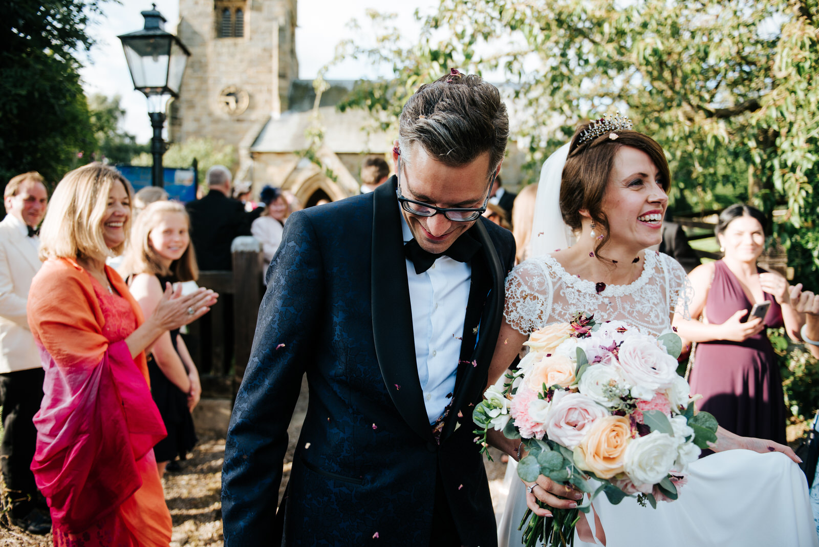 Bride and Groom exit the tunnel of guests while having confetti 