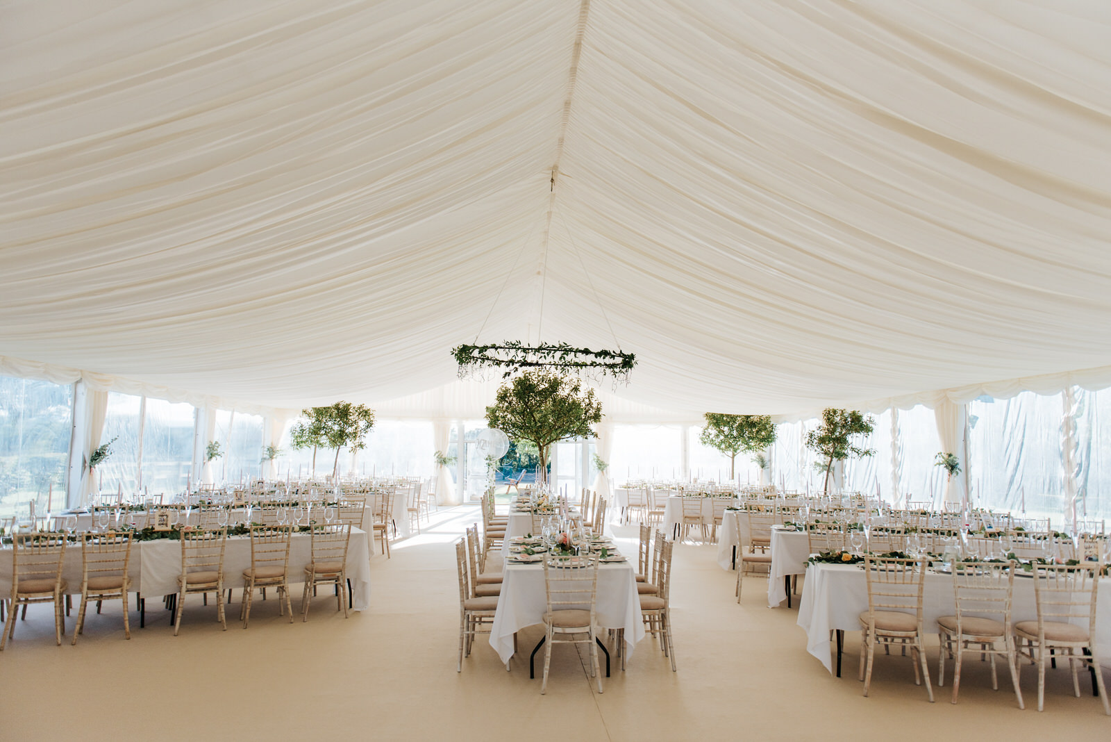 Beautiful white decor inside tree-lined garden marquee