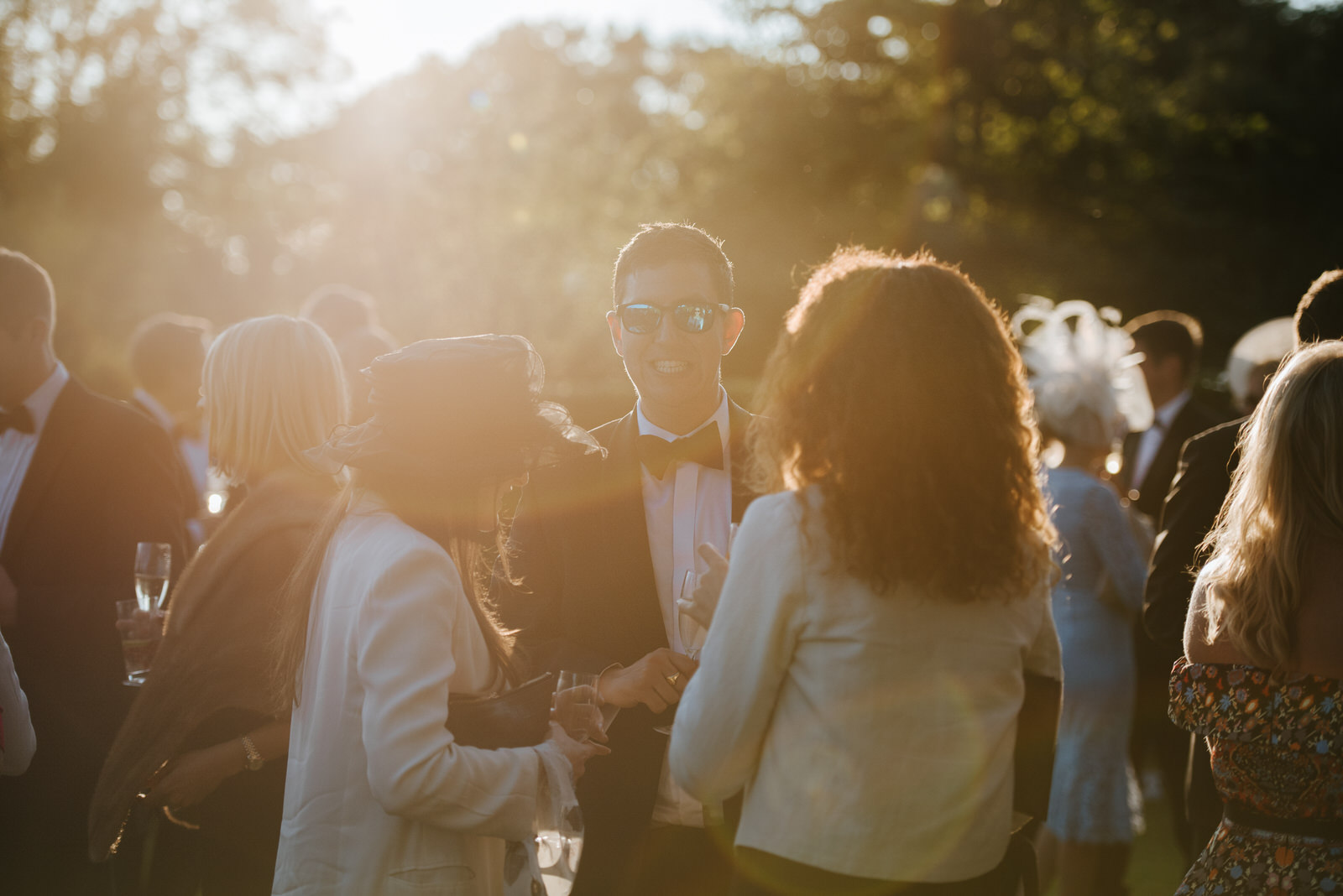 Sun-flare photo of guests talking to each other in garden