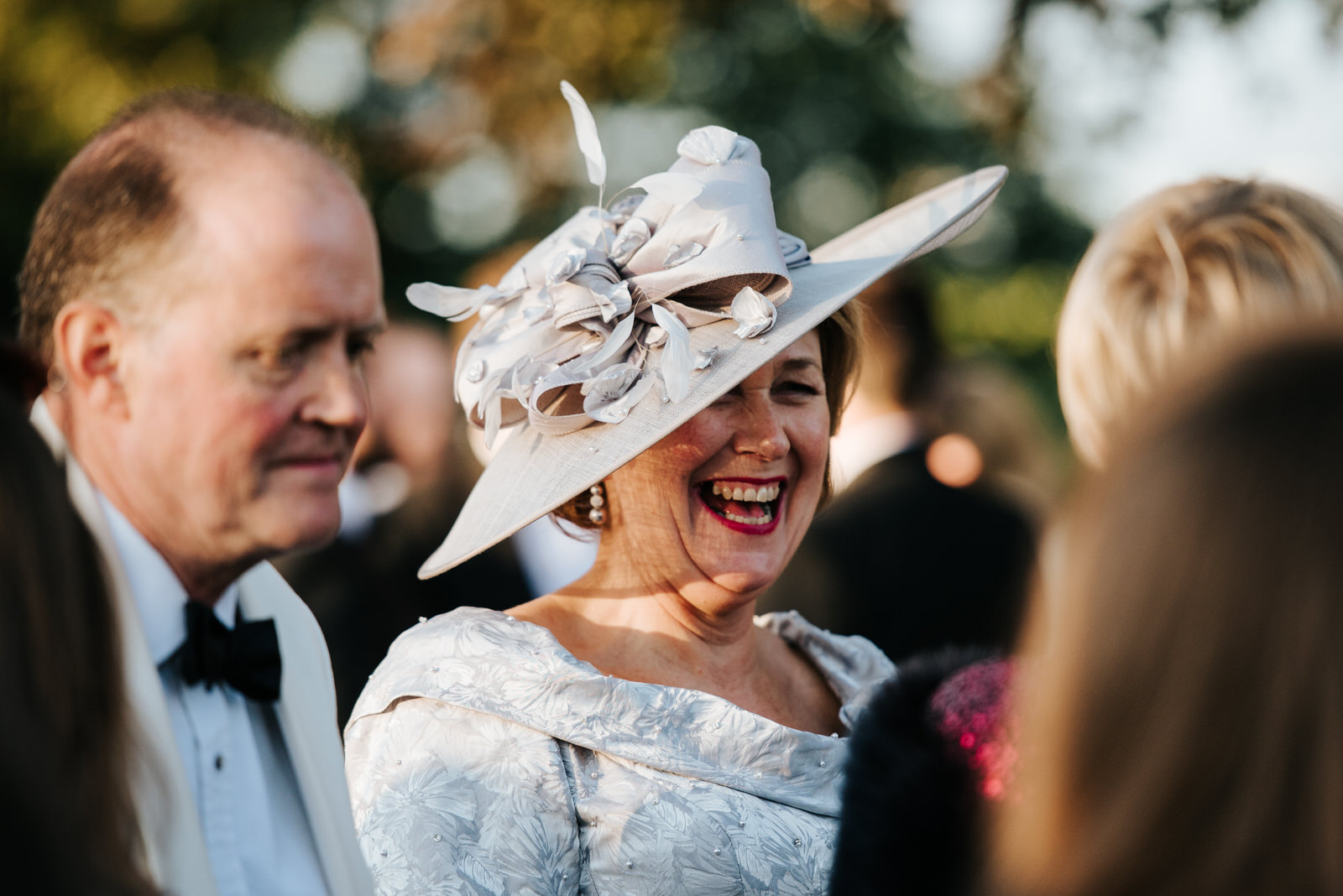 Mother of the bride overjoyed as she wears fabulous hat outside 