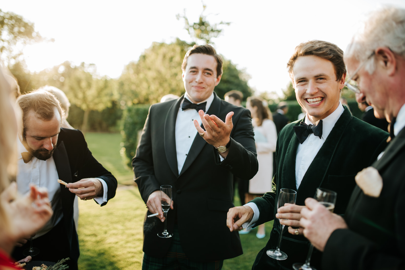 Groomsmen share a laugh and a drink during wedding reception in 