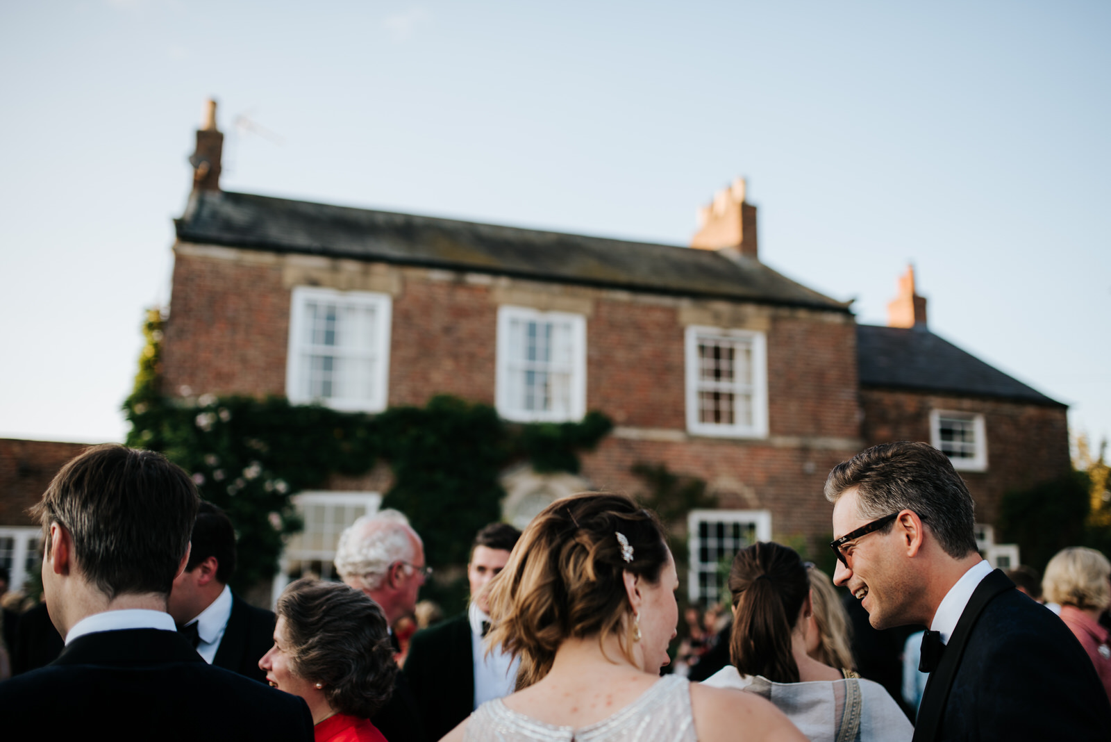 Groom smiles at guests during wedding reception