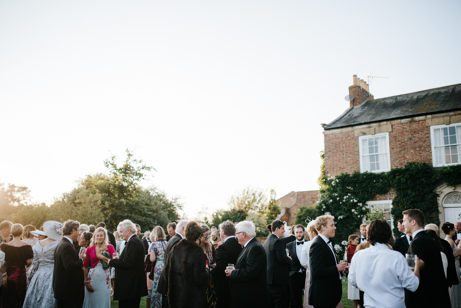 Wide shot of guests enjoying themselves during garden wedding re