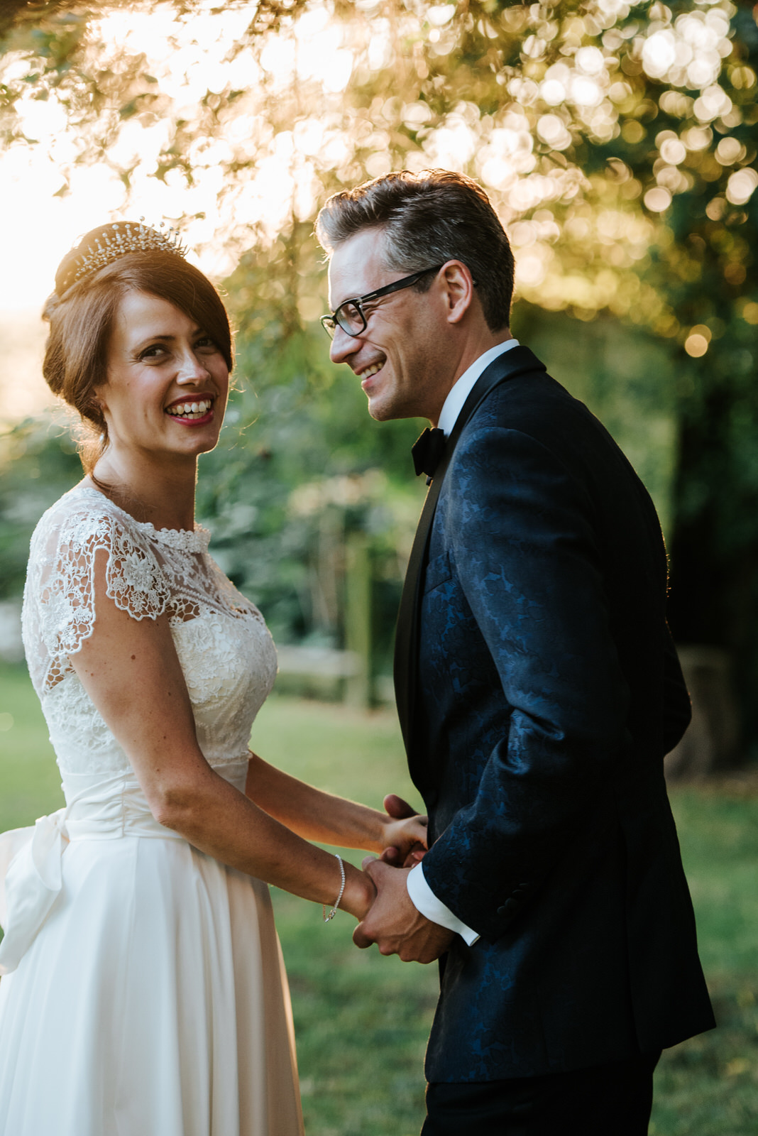 Bride and Groom hold hands in stunning garden setting as Bride l