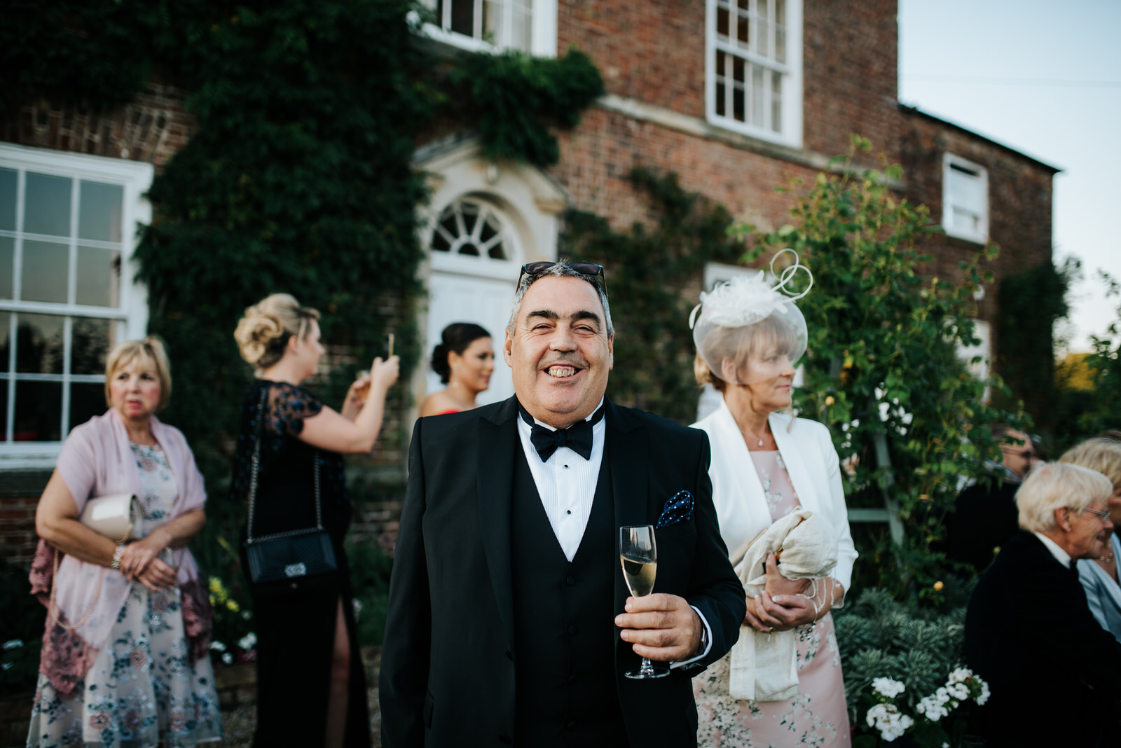Father of the Groom smiles into the camera as he poses for a pho