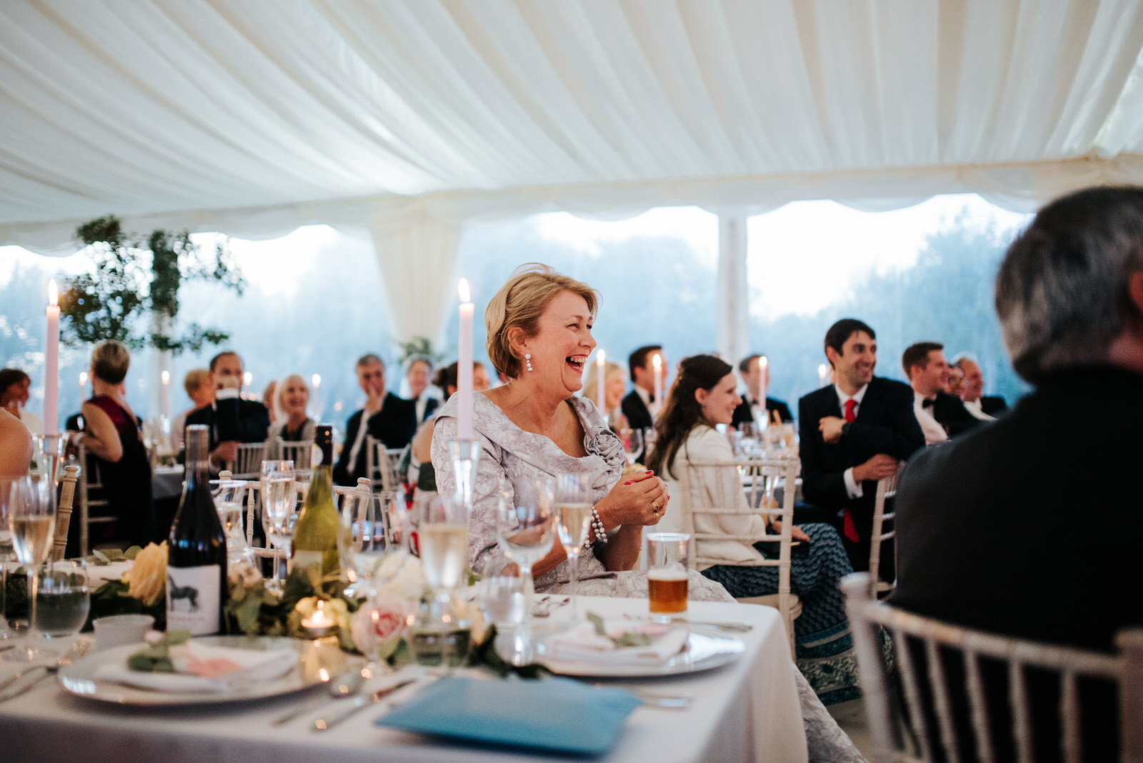 Mother of the Bride smiles during speeches inside Marquee