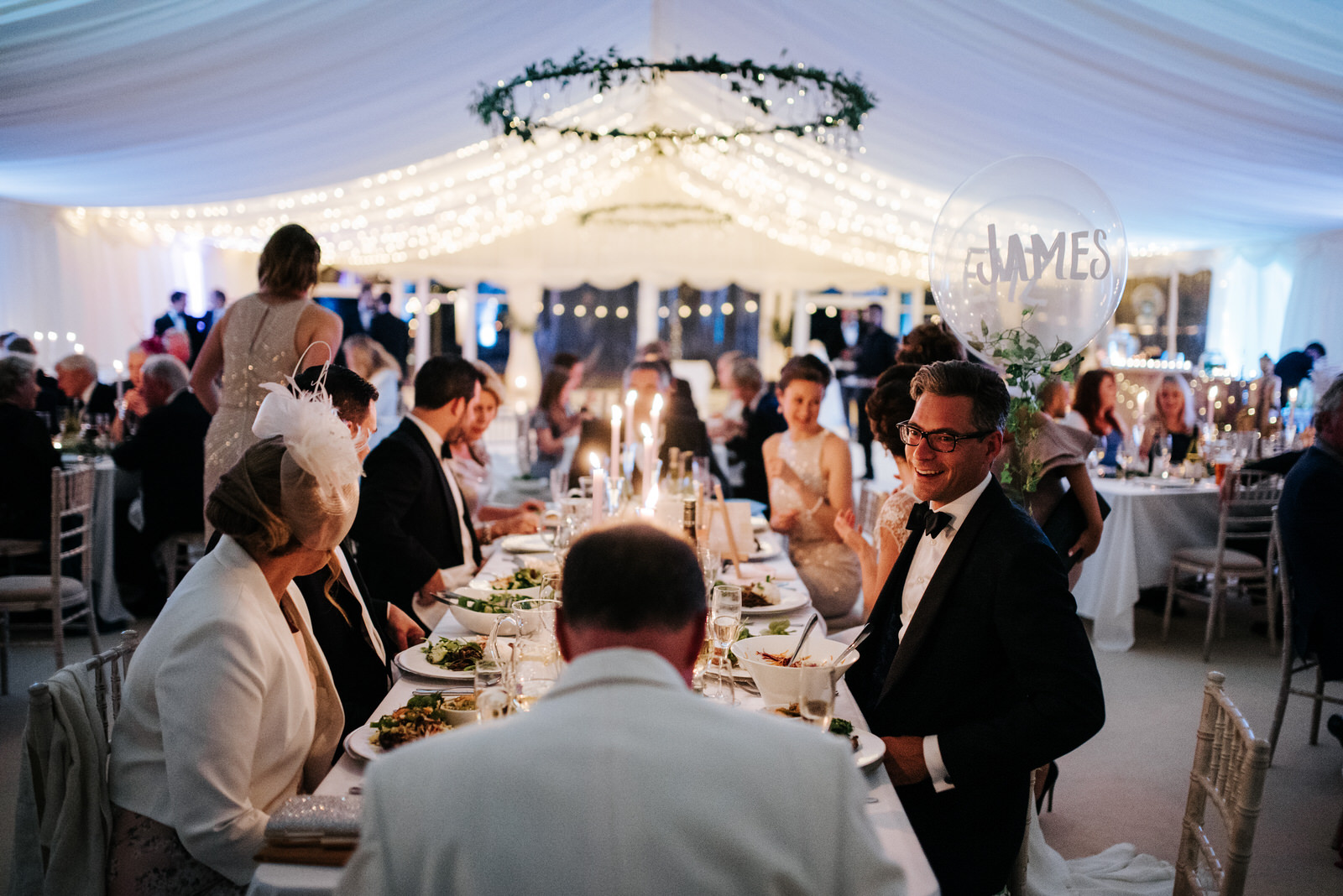 Groom sits down after speeches conclude and smiles at Father of