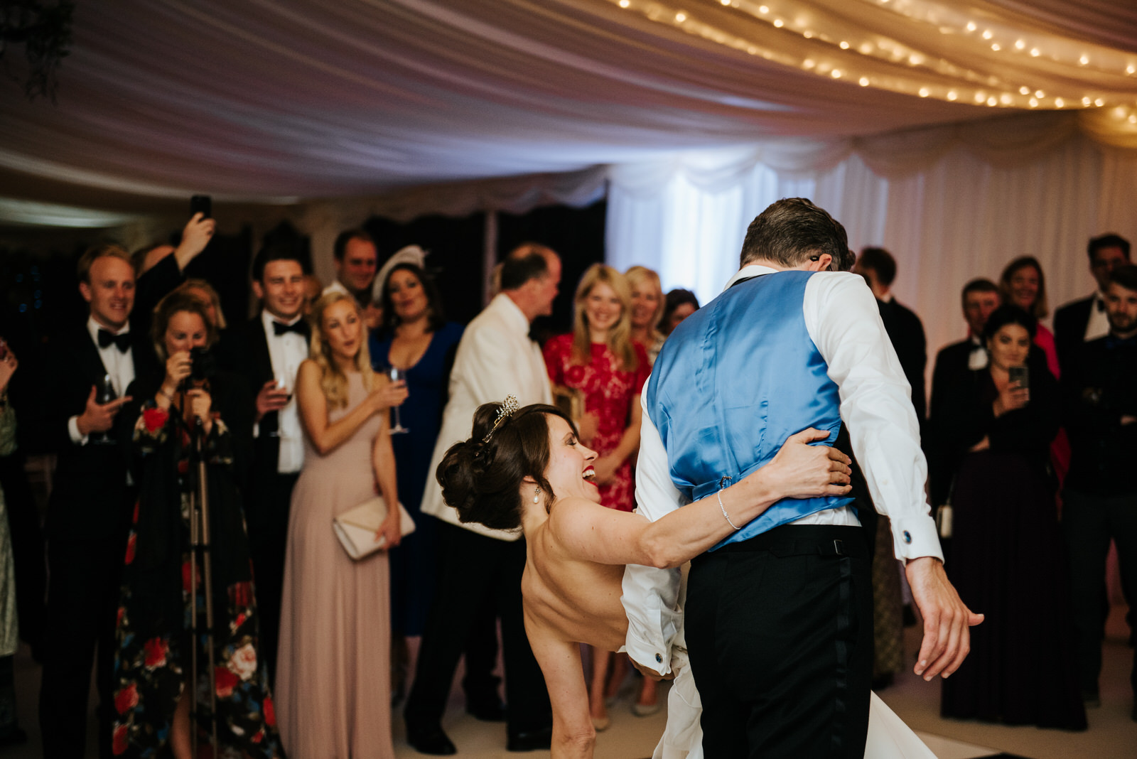 Groom dips bride as first dance inside marquee comes to an end