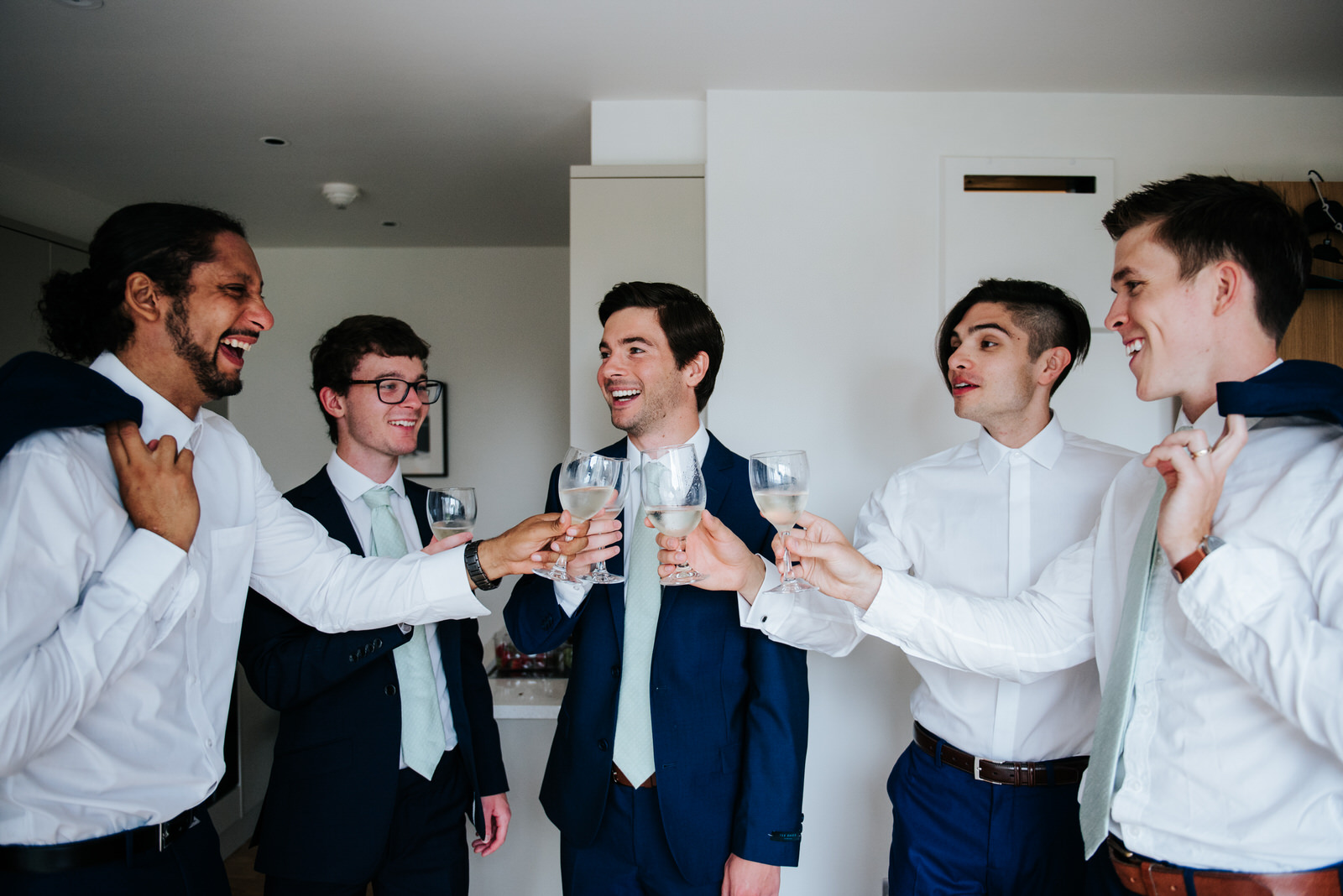 Groom and groomsmen share a toast as they finish getting ready