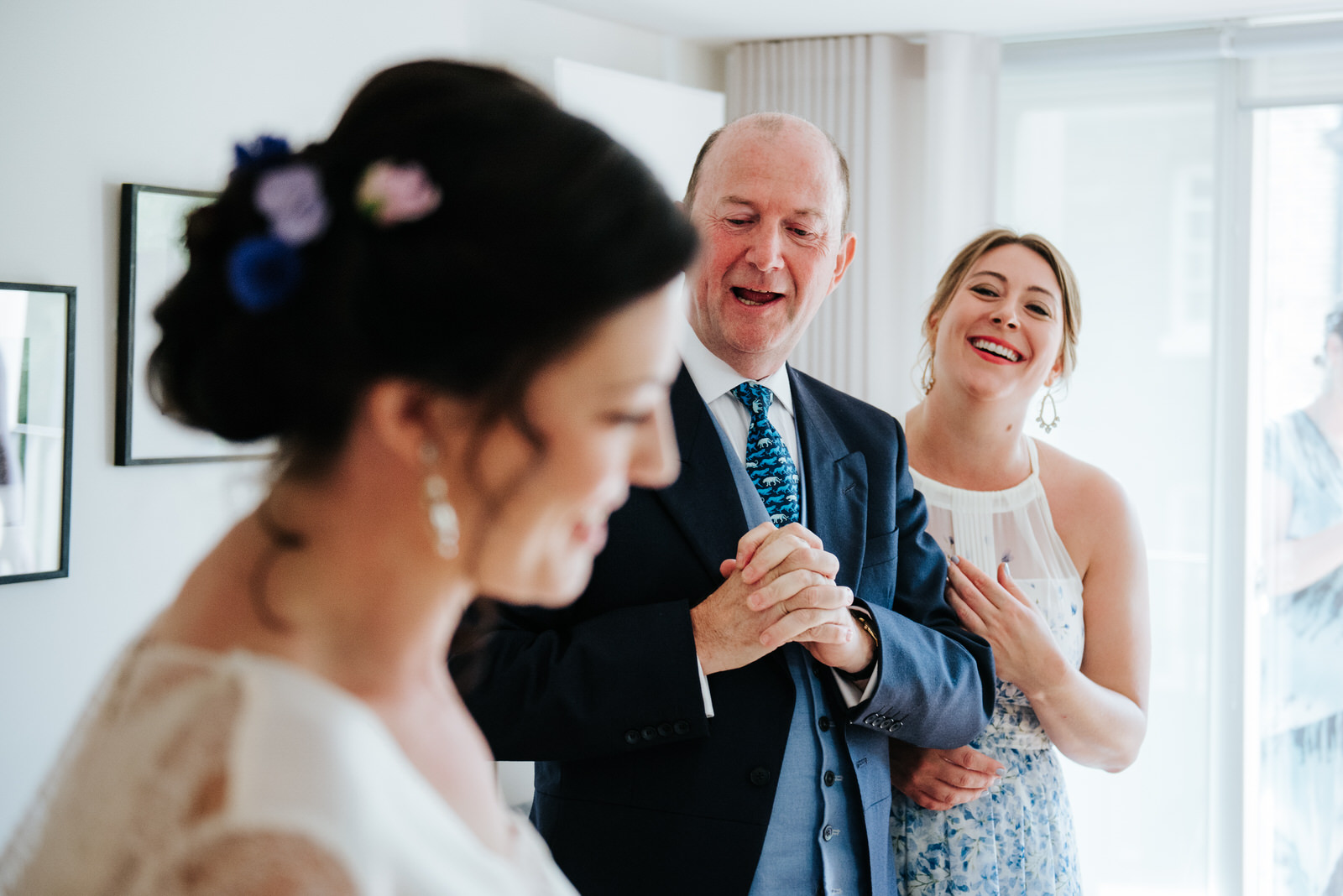 Father of the bride reacts and smiles after seeing her in her dr