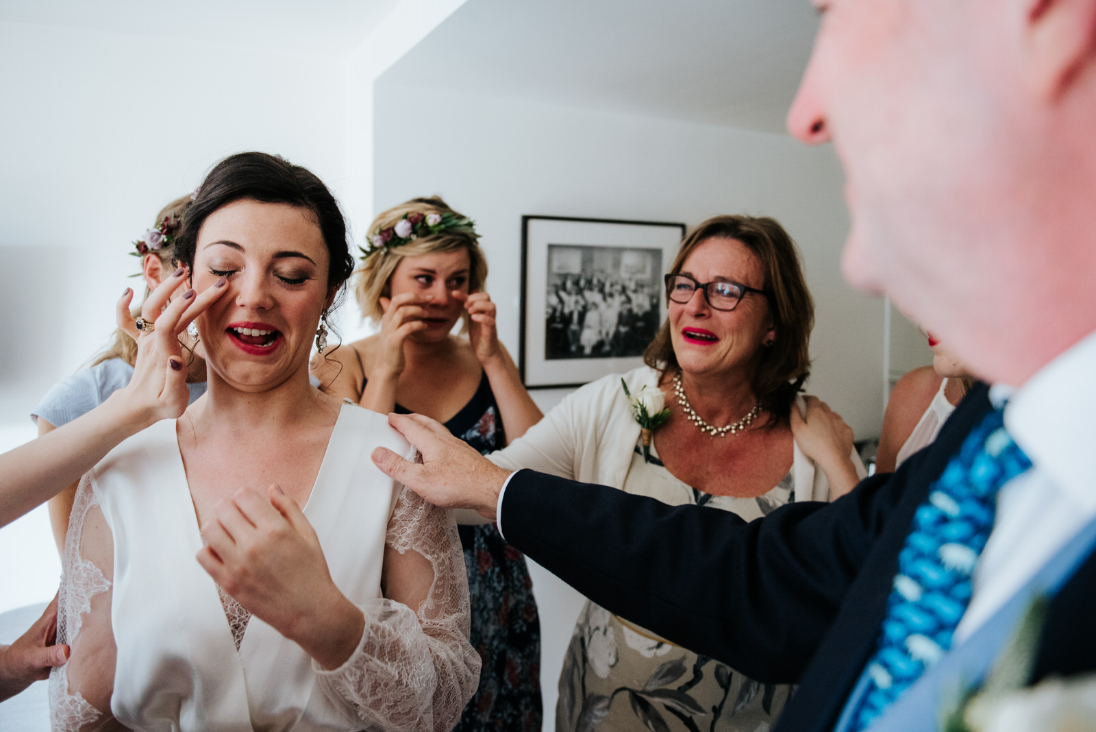 Bride cries as bridesmaids and parents form a circle around her 