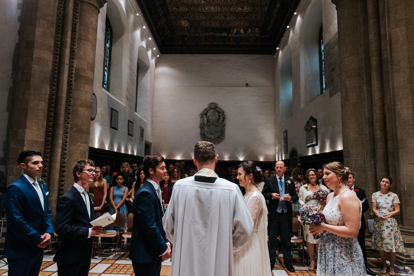 Wide shot of bridesmaids and groomsmen as they stand next to bri