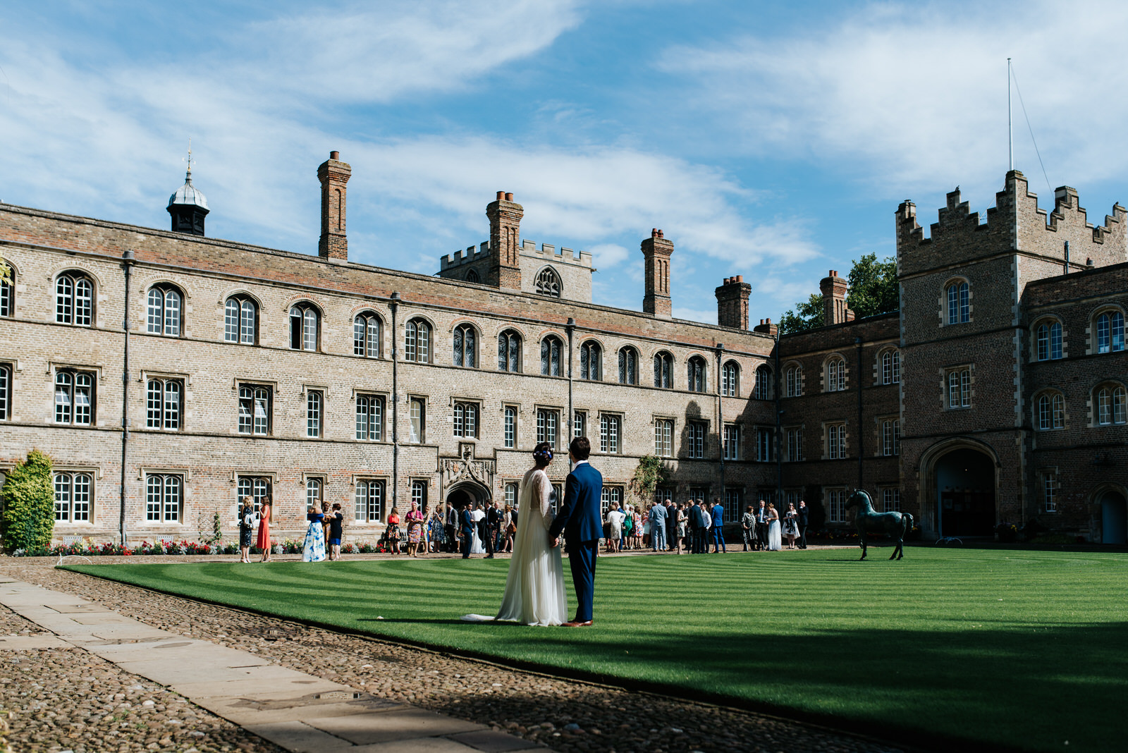 Bride and groom look towards guests as they enjoy themselves on 