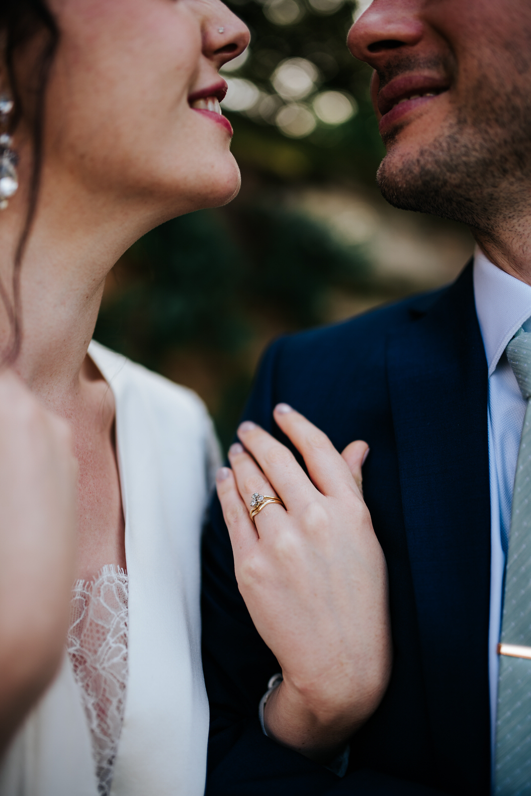 Bride shows off stunning diamond ring as she looks into groom's 