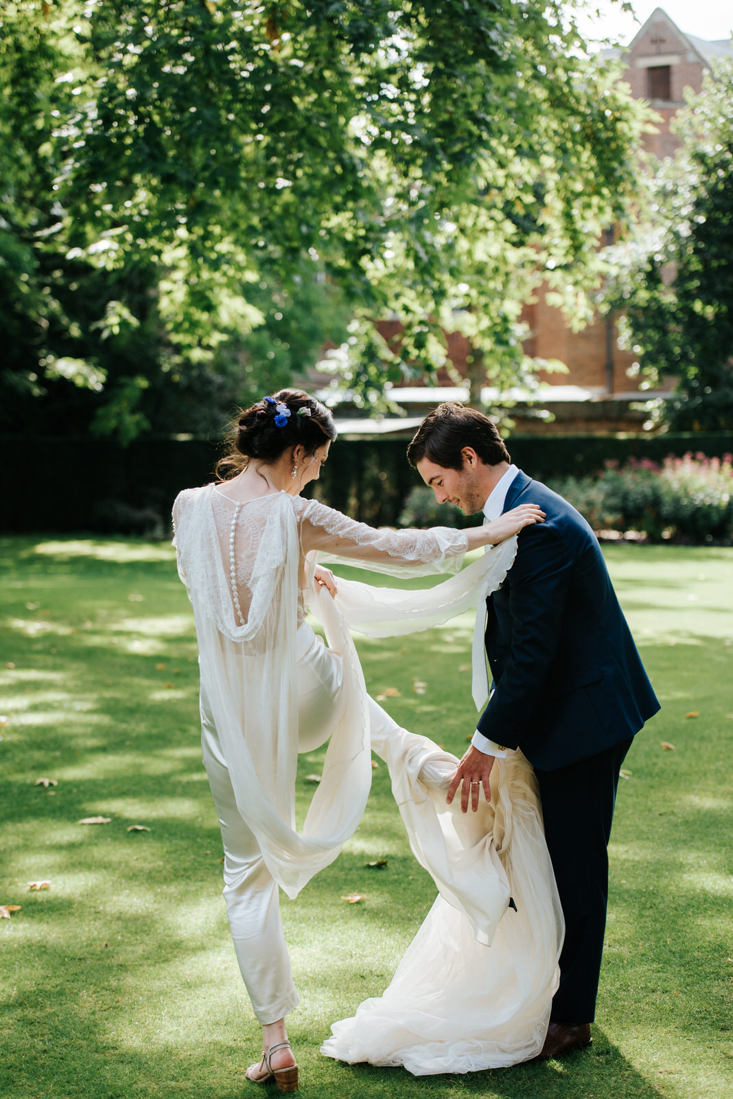 Groom helps bride take off her skirt to reveal wedding dress und