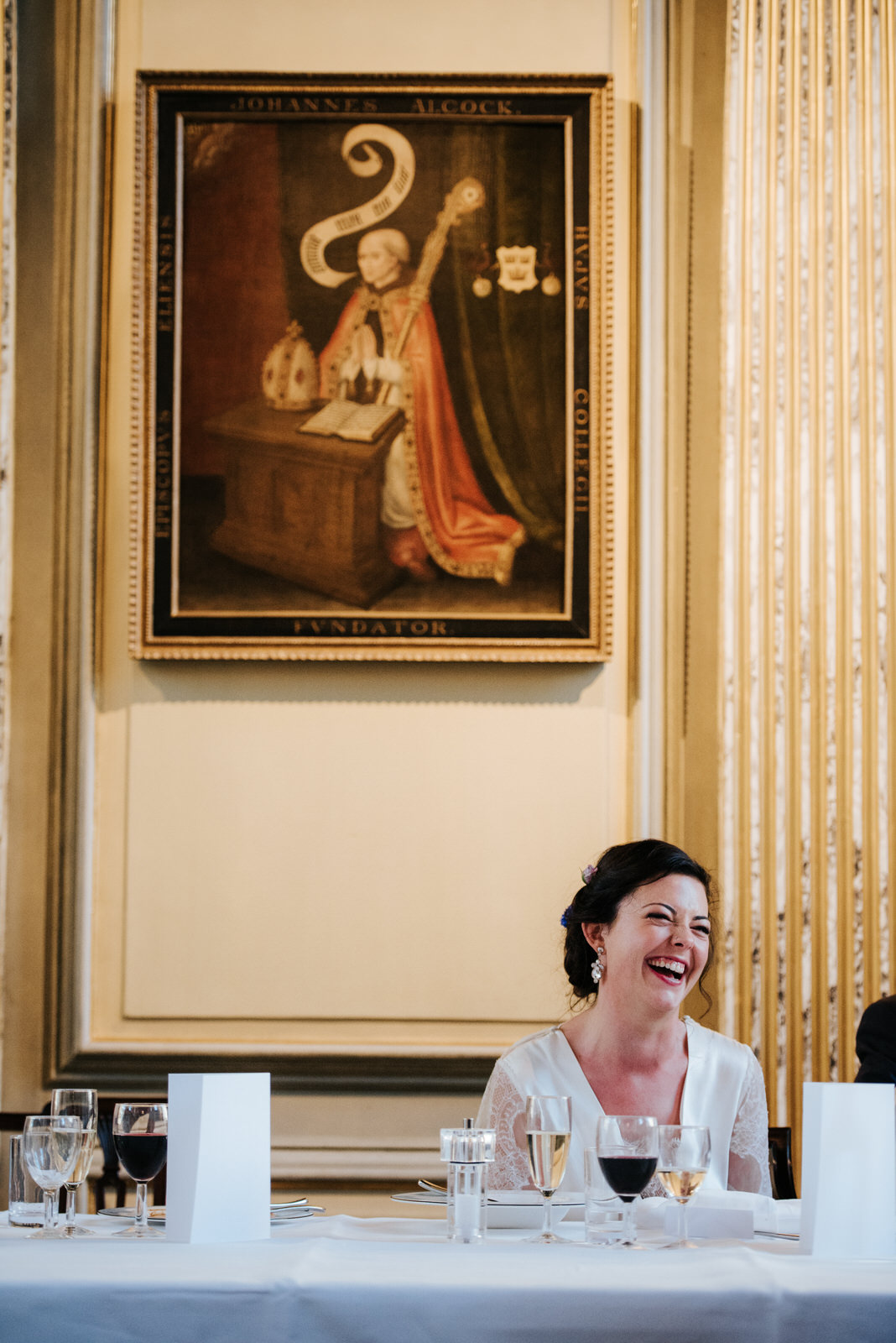 Bride reacts with laughter to joke during groom's wedding speech