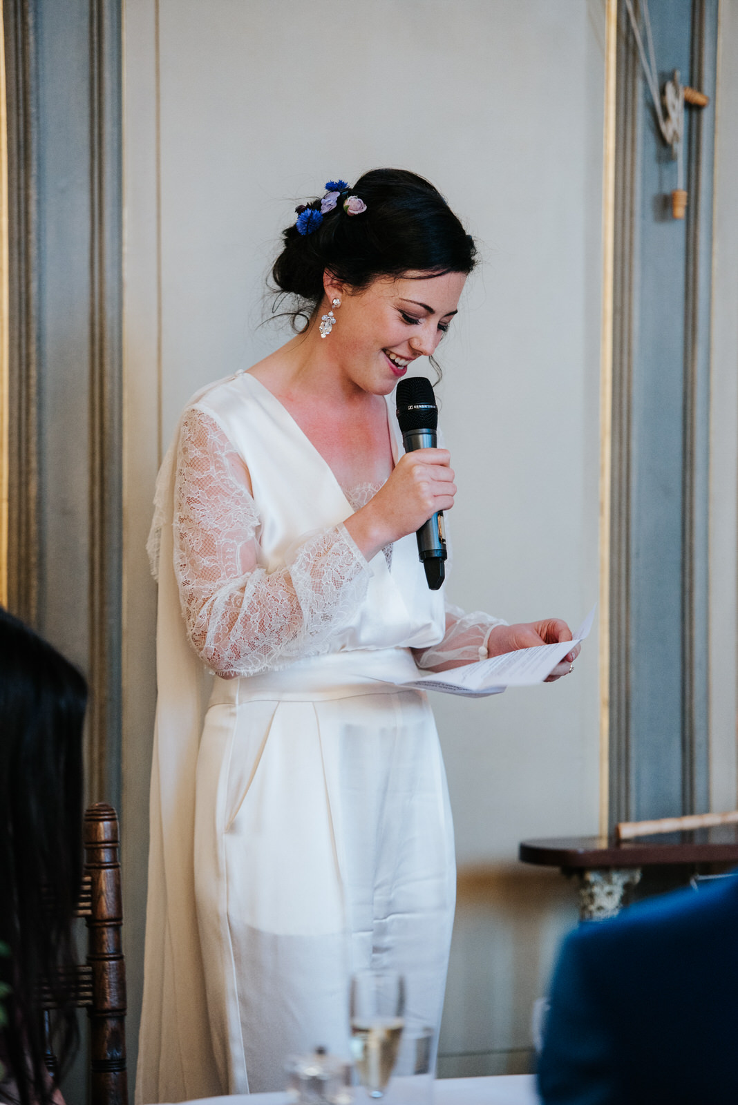 Bride reads from paper as she delivers her own wedding speech