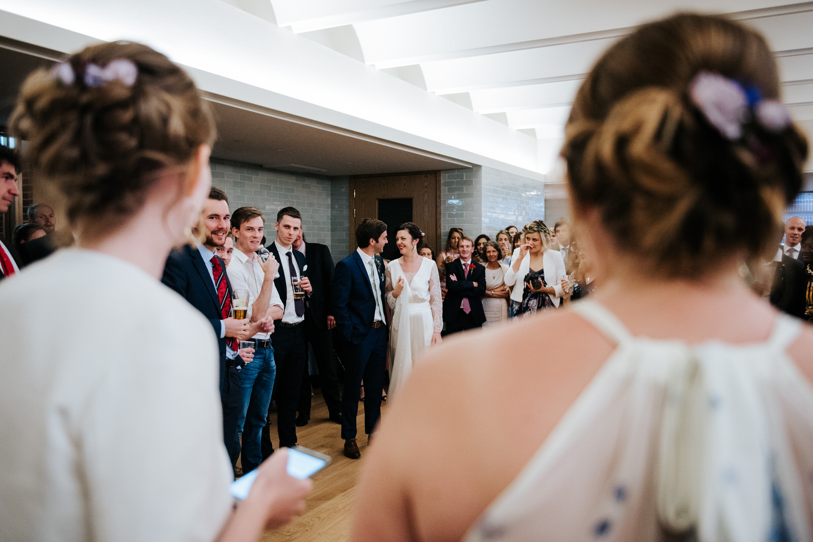 Sisters of the bride look onto bride and groom as they deliver t