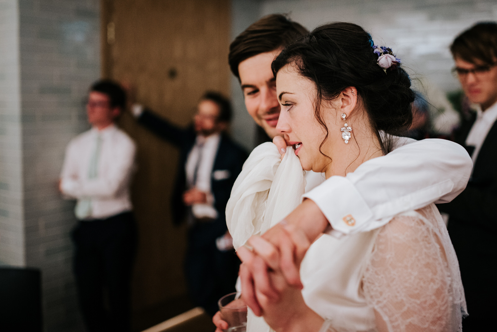 Bride reacts to speeches by tearing up as groom embraces her