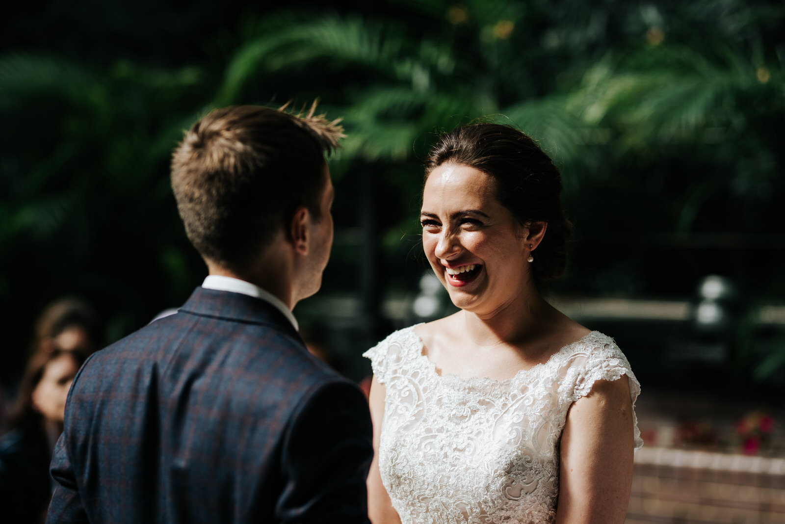 Bride and groom hold hands and exchange vows as bride has an out