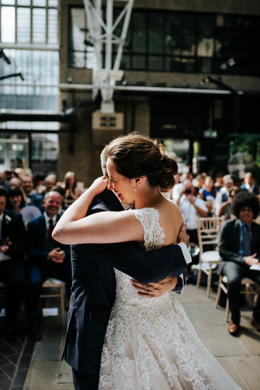 Bride and groom embrace each other in a joyful hug after sharing