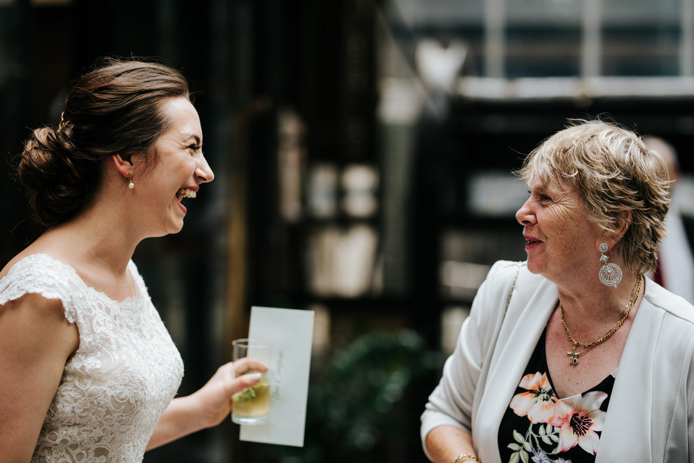 Bride smiles at family member as everyone says hello after weddi