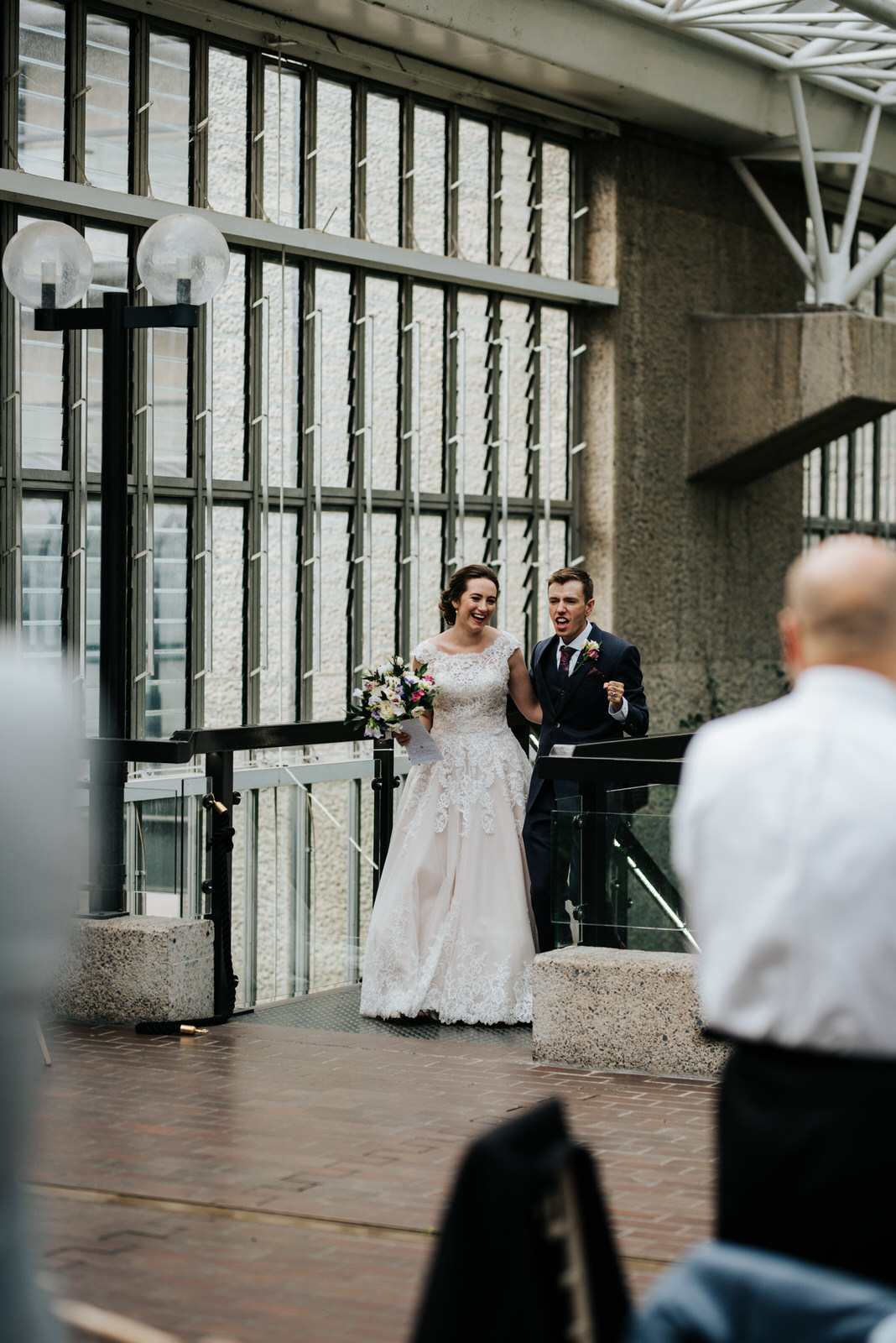 Bride and groom make their entrance into wedding breakfast room