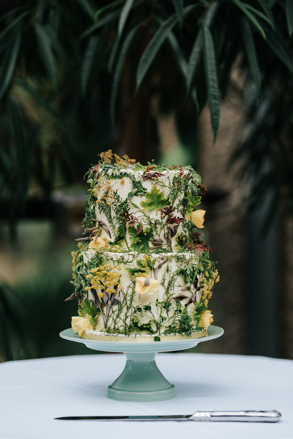 Detail photograph of stunning wedding cake decorated with shrubs