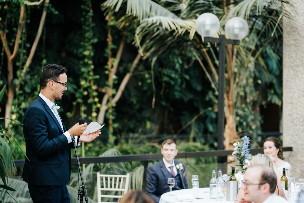 Best man delivers heartfelt speech while bride and groom listen 