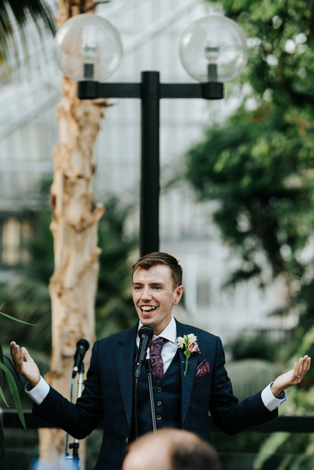 Groom looks happy and amused as he starts delivering his wedding