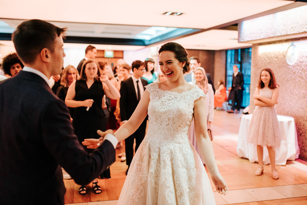 Bride smiles as she and groom begin their first dance