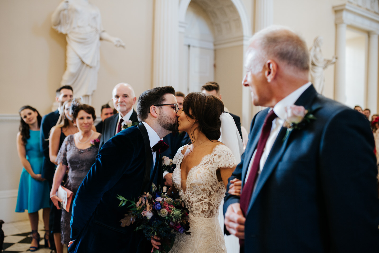 Bride and groom see each other at the front of the aisle and kiss