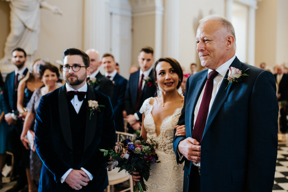Bride smiles at step-dad as he holds her close and looks proud