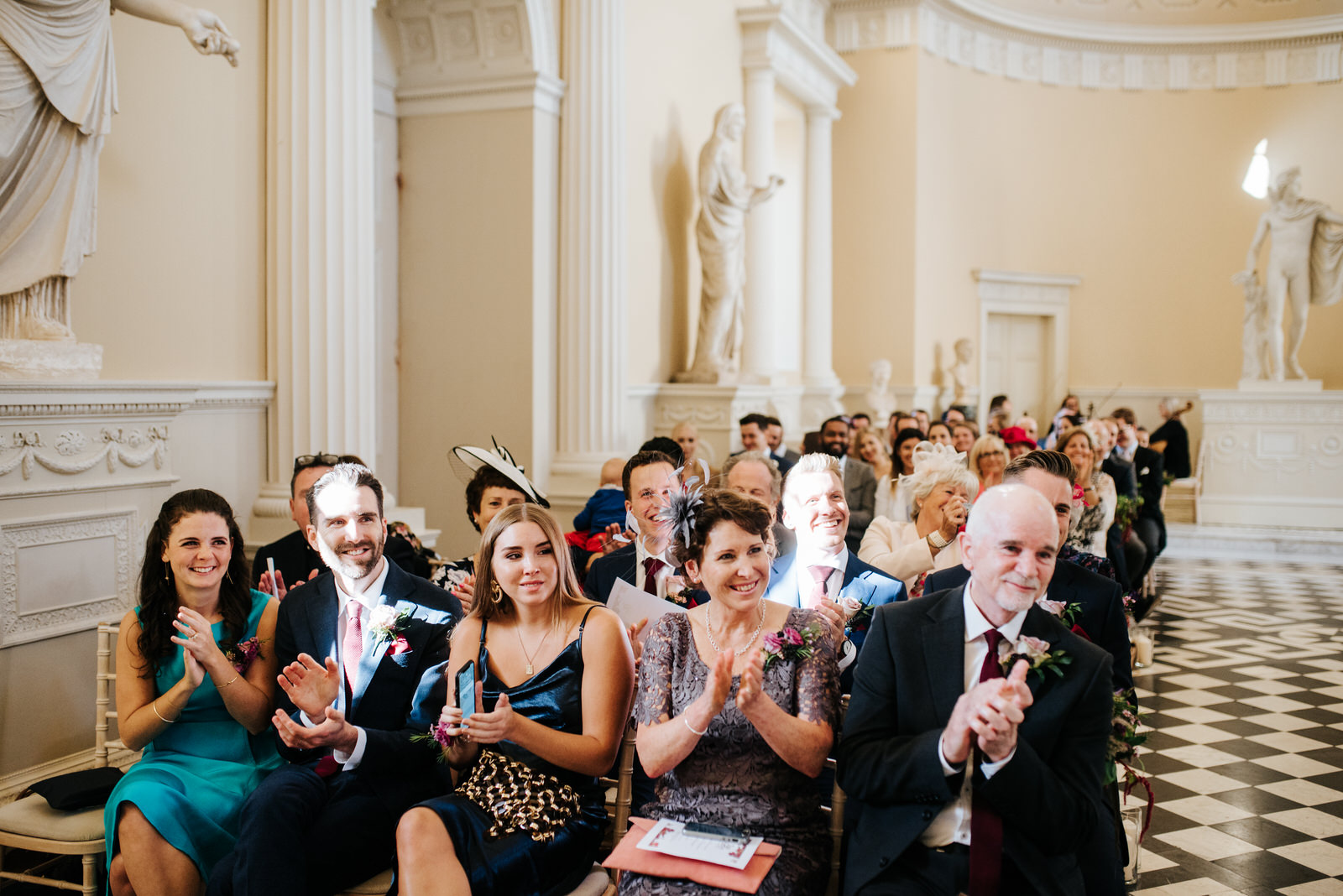 Groom's side of the family laughs and applauds as ceremony comes to an end