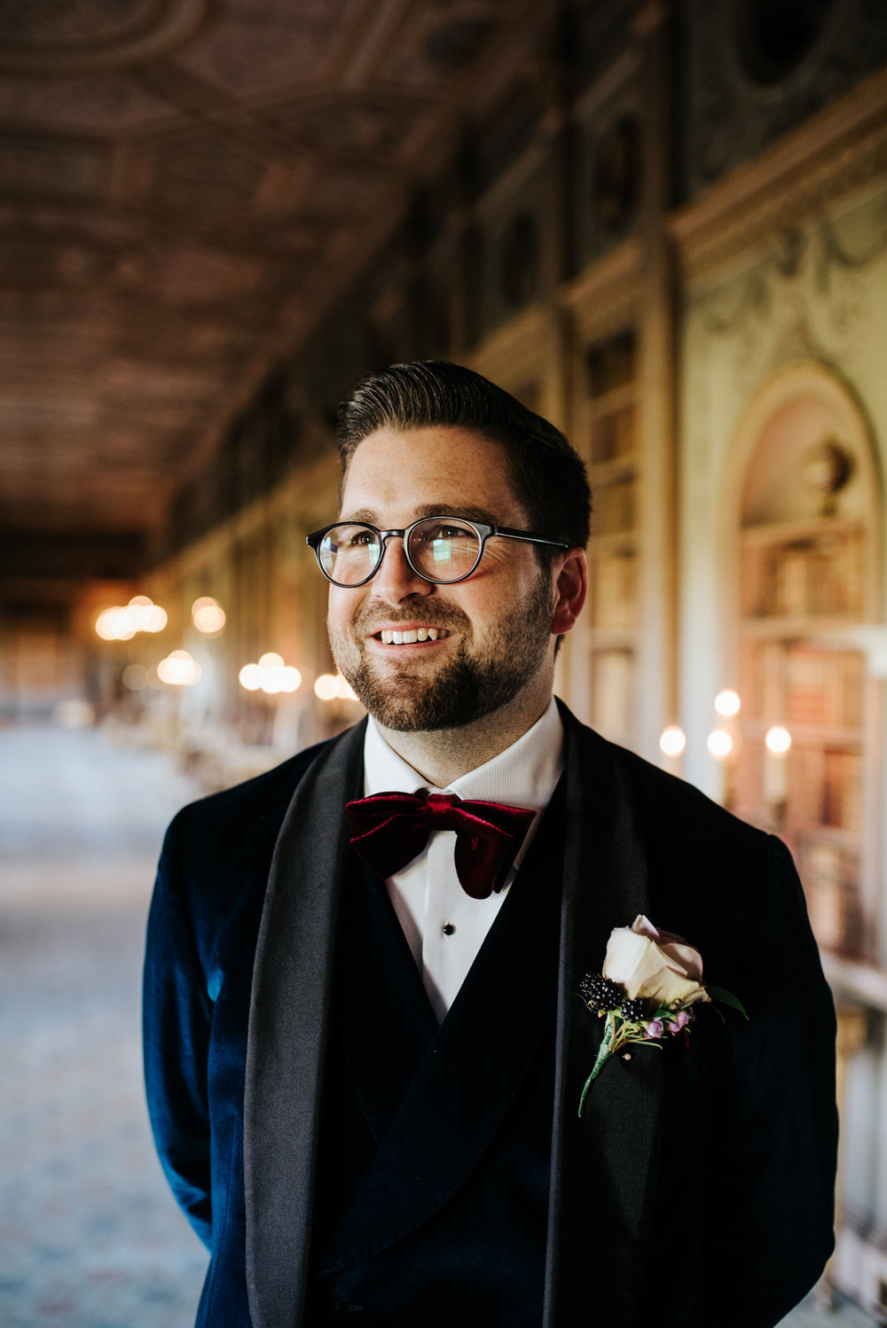 Candid portrait of the groom as he stands in Syon House's library room and looks dapper