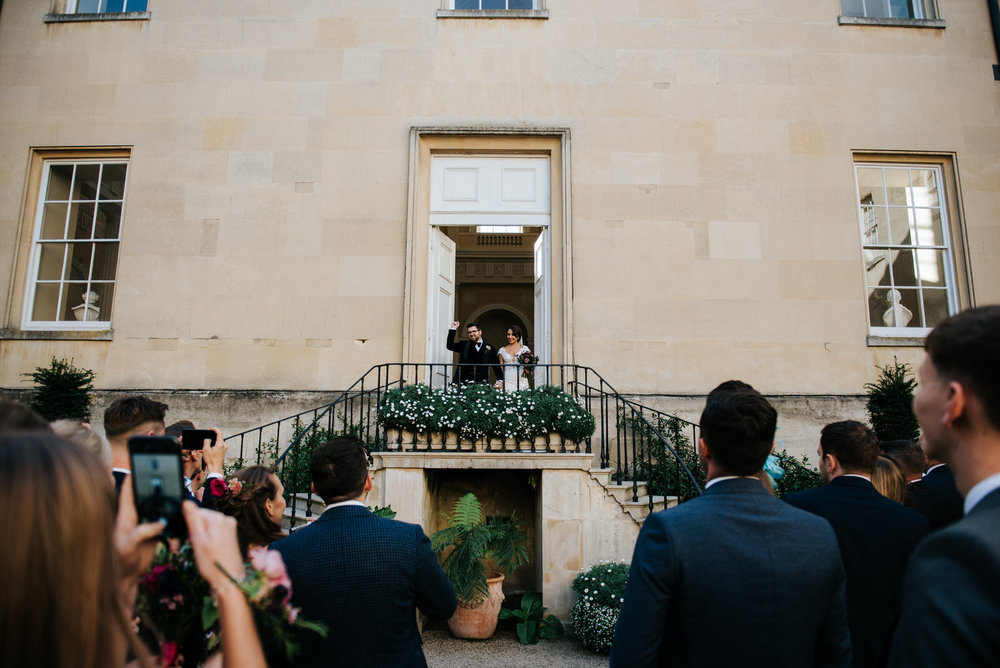 Bride and groom are announced into Syon House inner courtyard as their guests smile and applaud